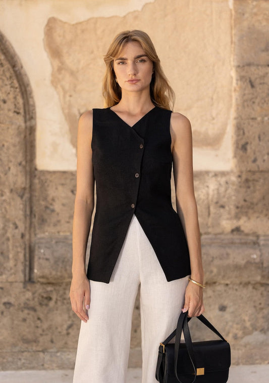 Dames elegante outfit met zwarte mouwloze blazer top en lichte broek